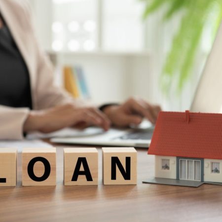 loan with home model on desk with banker Loan approval and mortgage or cash advance concept.